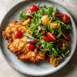 Crispi Chicken bun with an heirloom tomato and arugula salad
